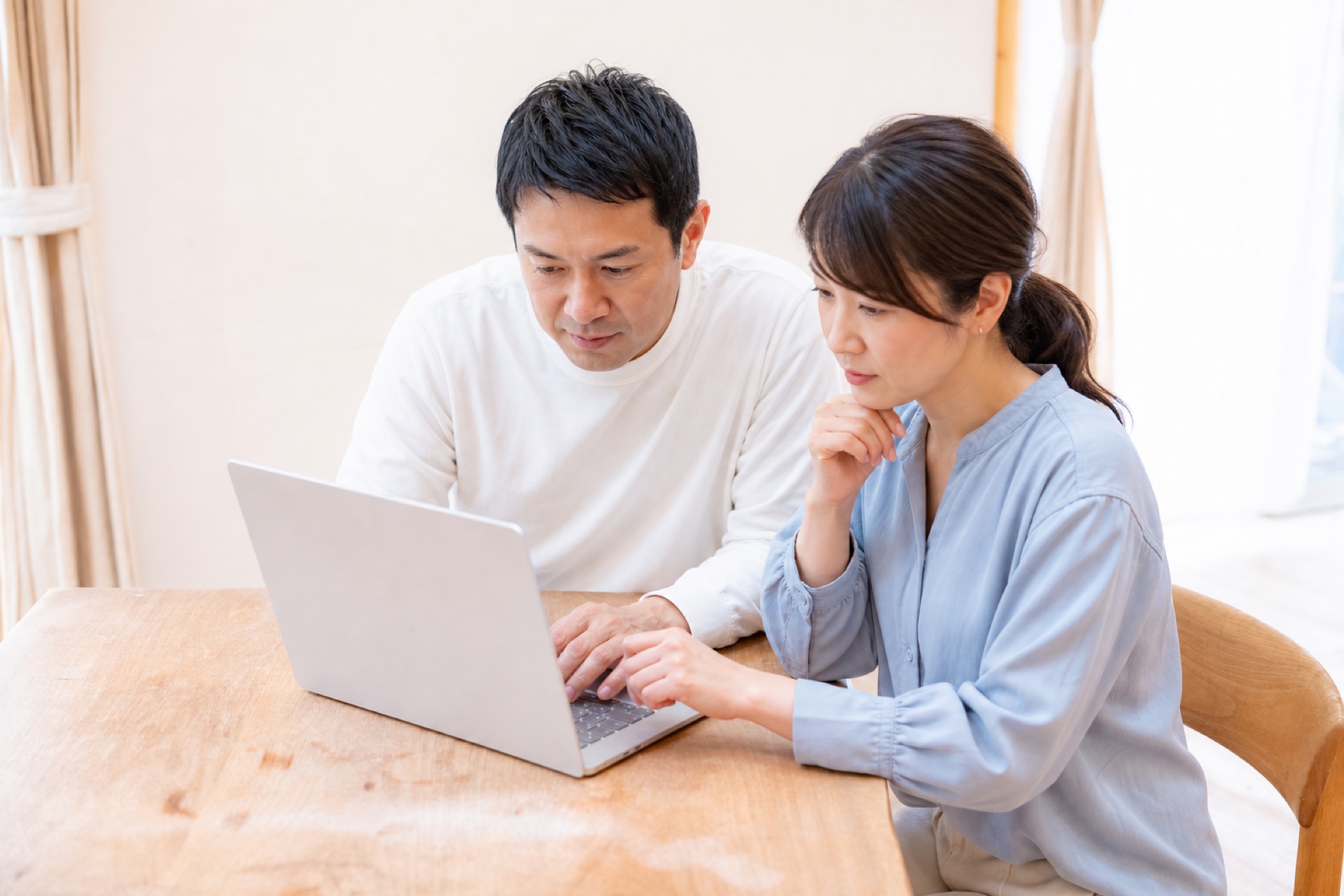 ノートパソコンを見ながら老後資金について考えるシニア夫婦